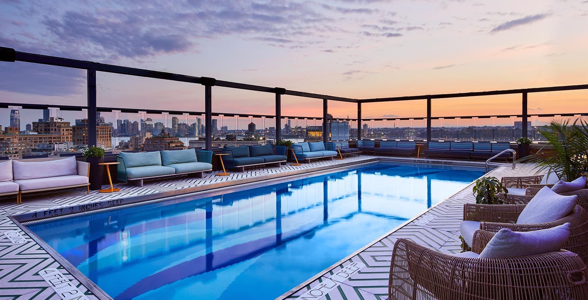 Rooftop pool at sunset with lounge chairs
