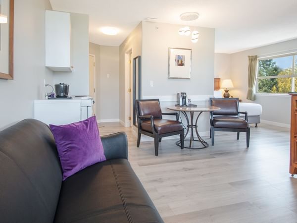 Hotel suite with queen bed, couch, flat screen TV, table and chairs