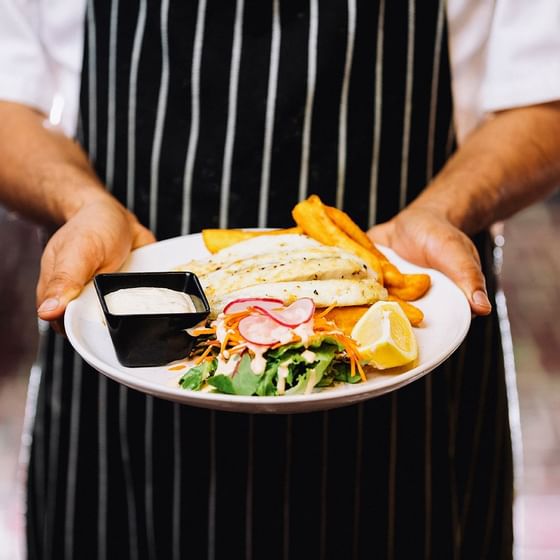 A chef holding a dish served at ReStays Ottawa