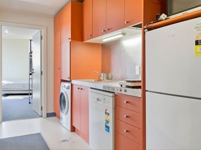 Modern kitchen with appliances and orange cabinets at UniLodge Stafford House.