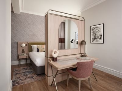 Stylish suite at The Met Hotel Leeds, England, with a desk divider, an arched mirror, and modern map wallpaper