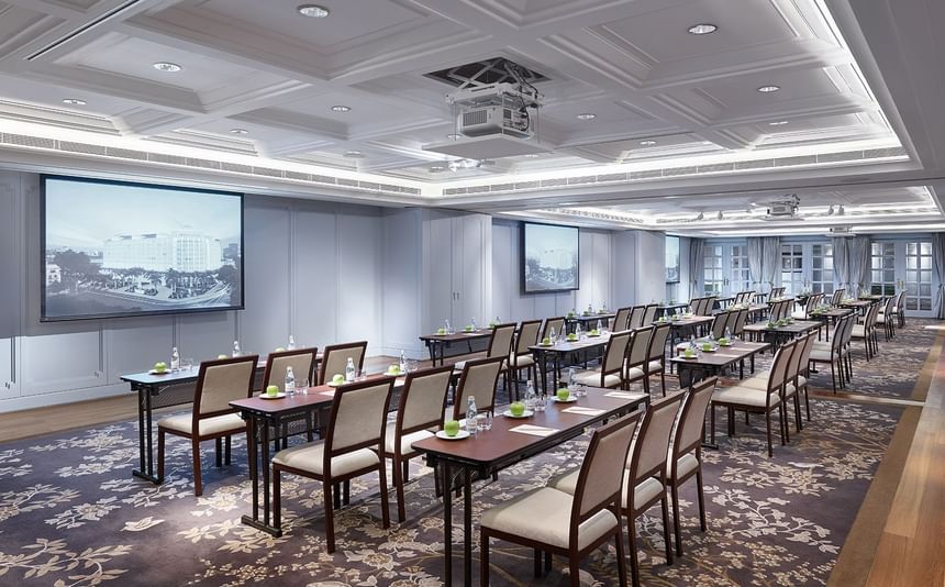 Classroom-style setup with multiple tables and chairs facing the projector screen at Park Hyatt Saigon