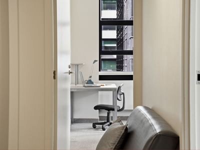 Desk with a chair and a couch in a room at UniLodge Stafford House.