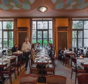 Partner Restaurants in Berlin with wooden tables and chairs and large windows at Titanic Comfort Mitte