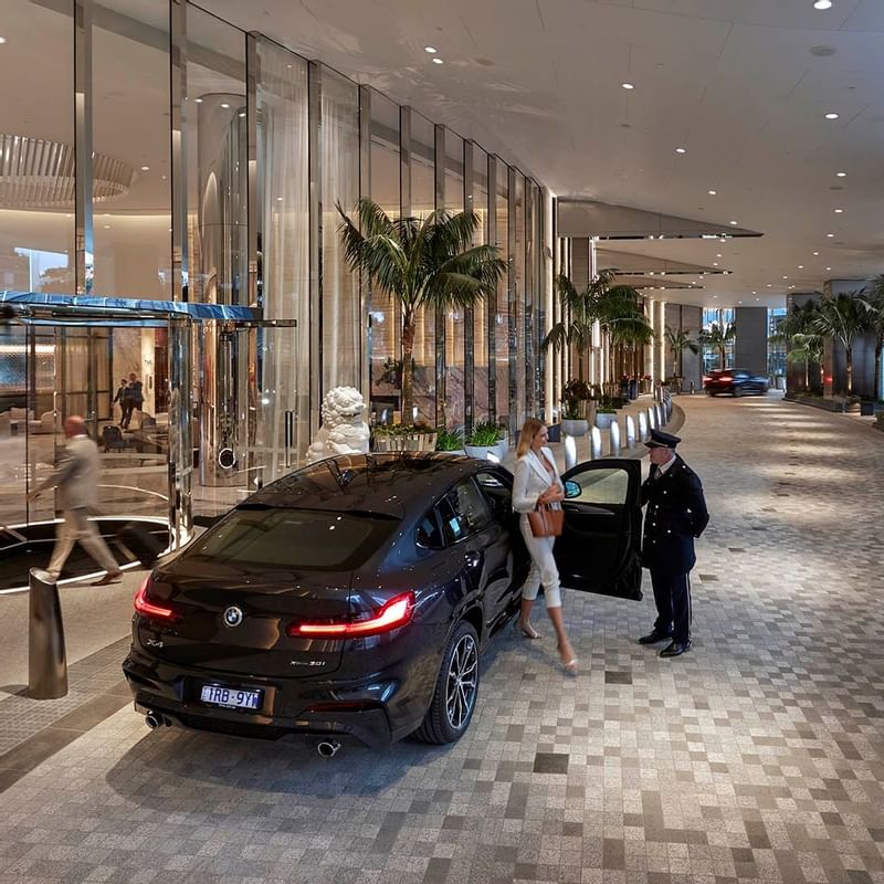 Doorman opening car door for a woman at Crown Towers Sydney