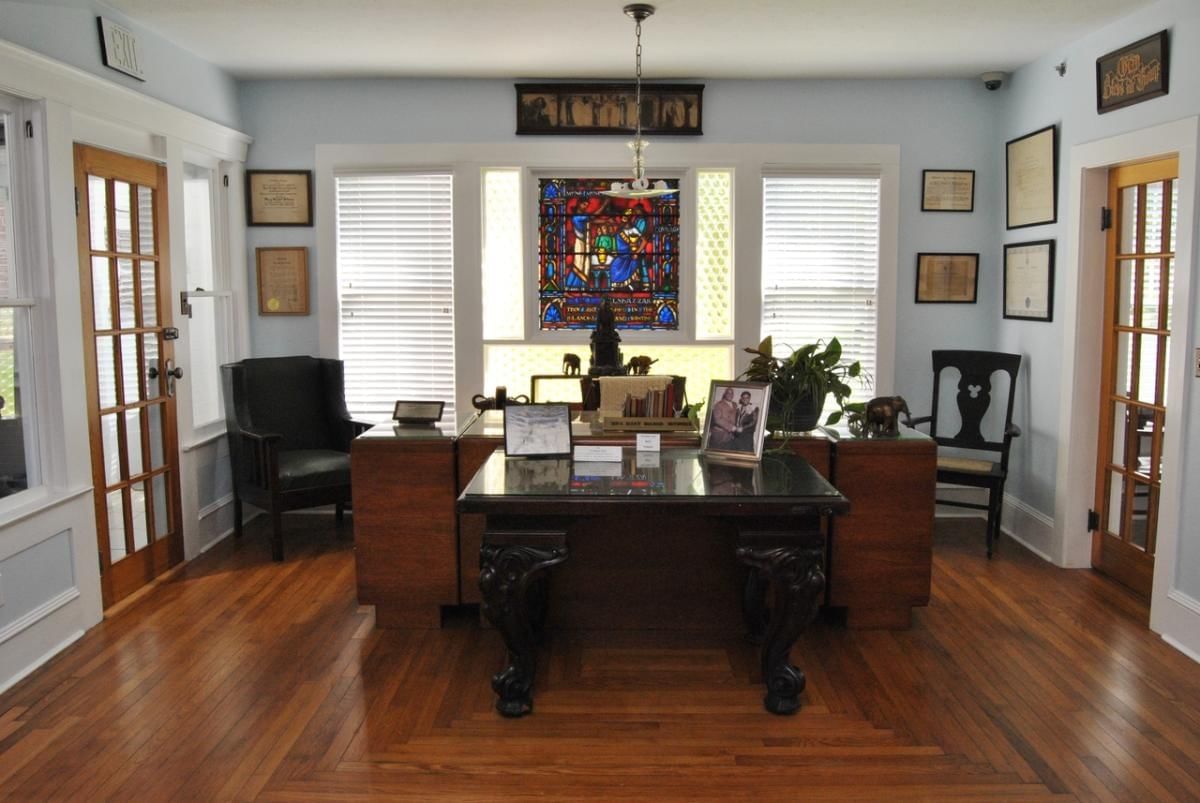 A lobby with a large desk and stained glass window