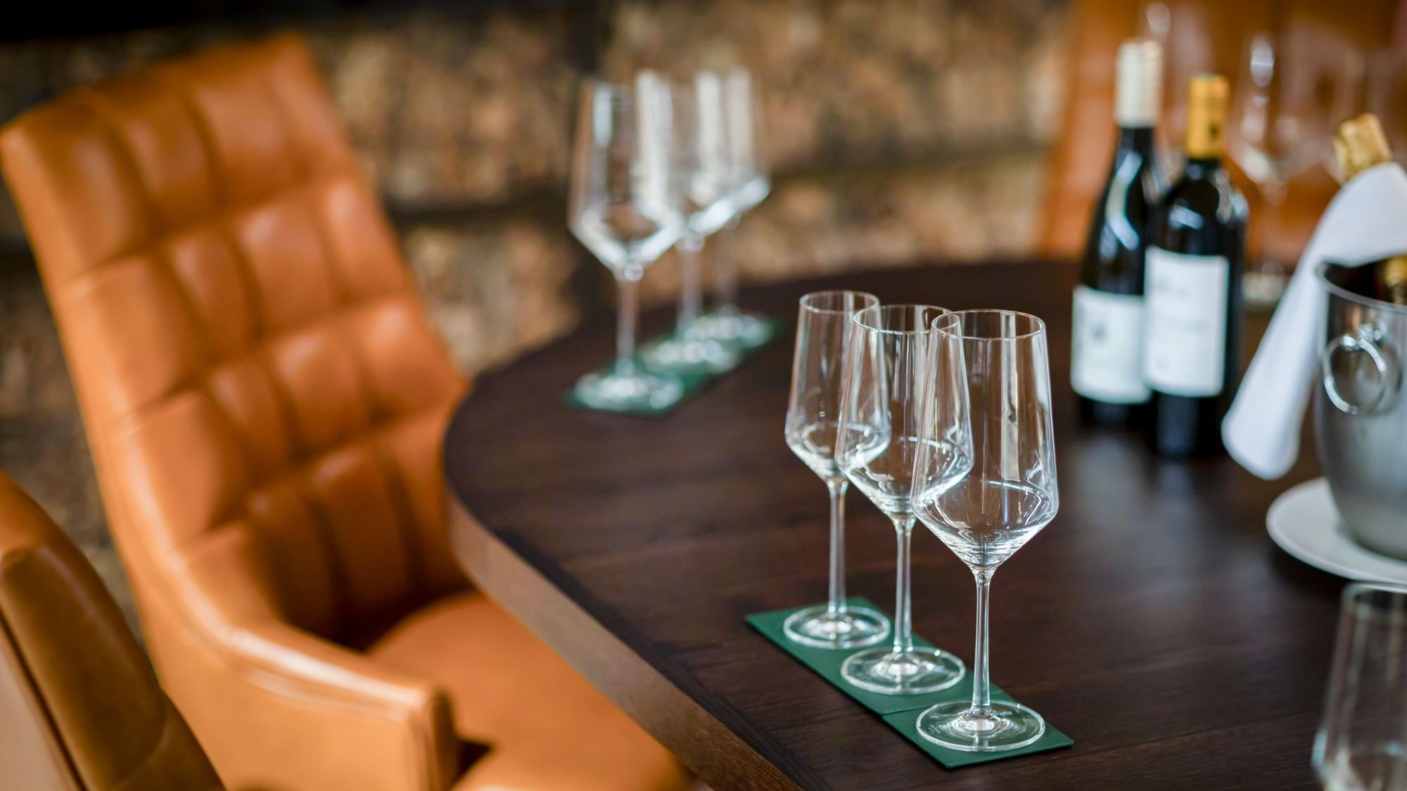 Vault with a wooden table set for a wine tasting, with bottles and empty glasses on coasters at Dunluce Lodge