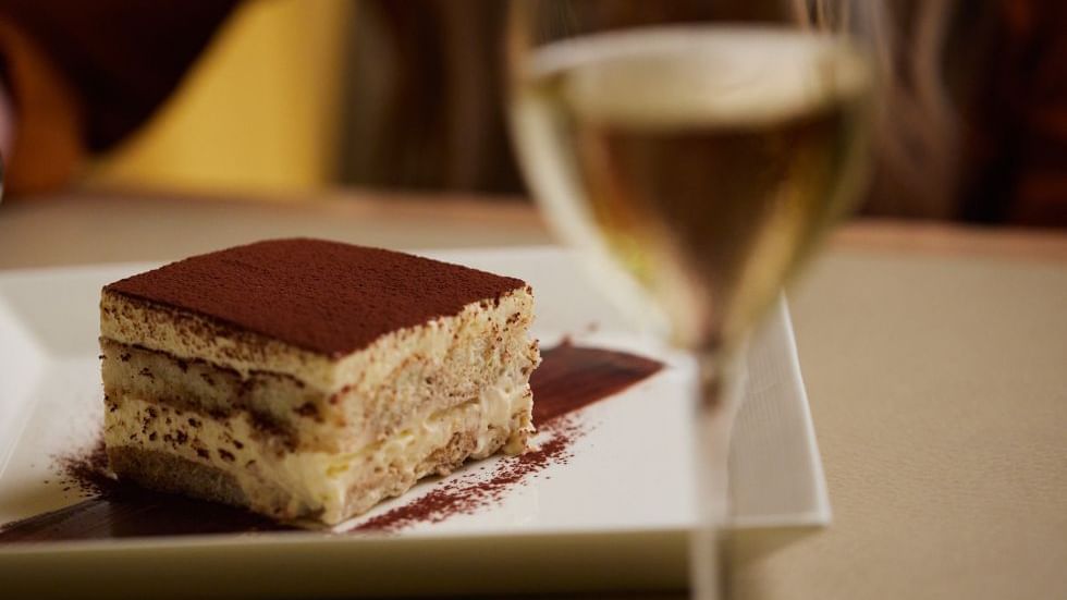 Slice of cake on a plate with a glass of wine in Modo Mio at Crown Promenade Perth