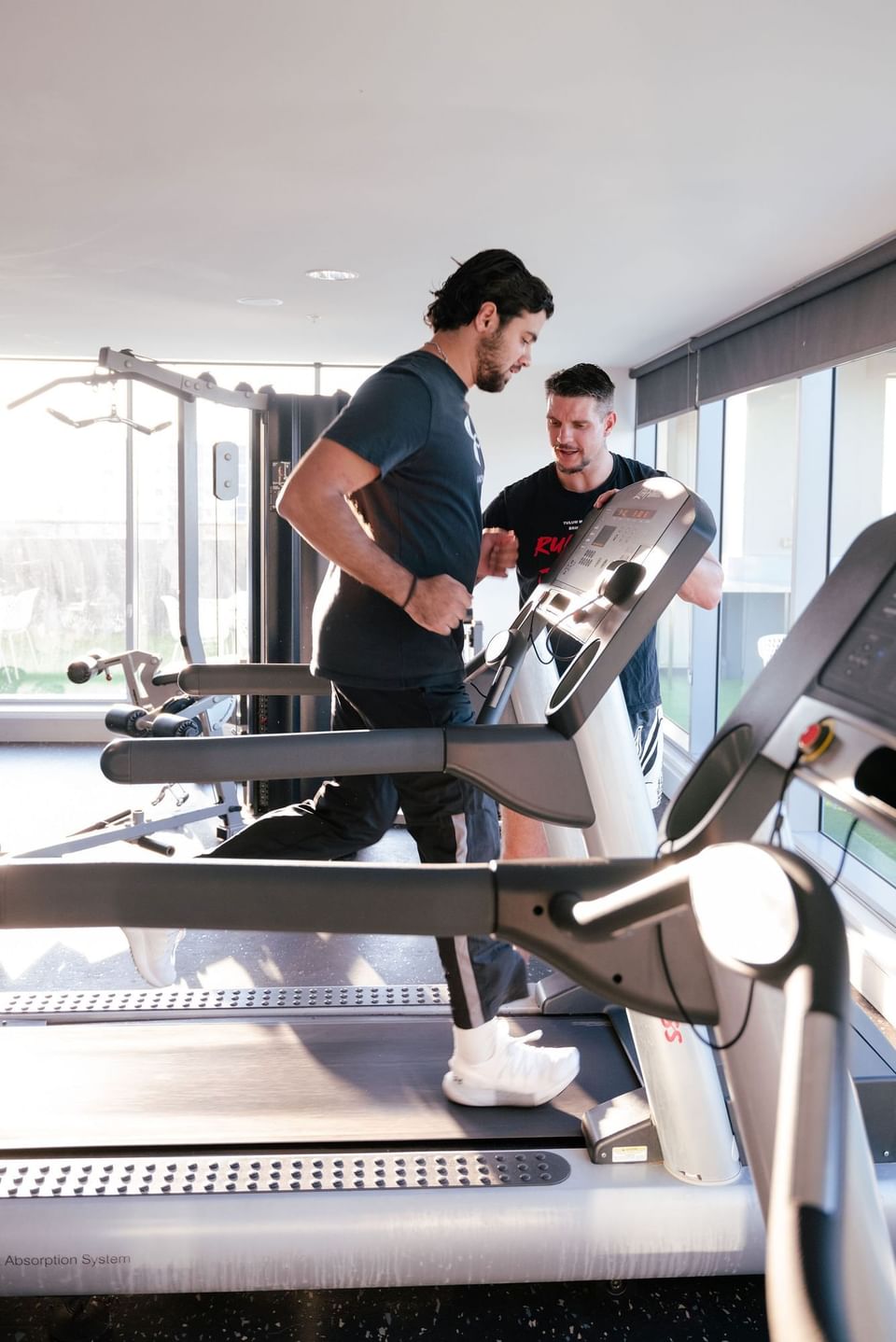 Two individuals using treadmills in a gym at H on Mitchell