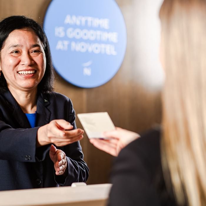 Receptionist handing over keycard at Novotel Glen Waverley