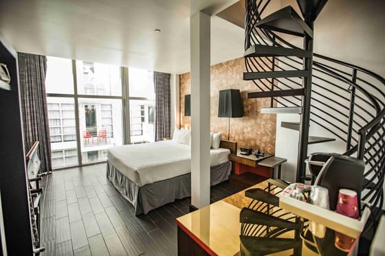 Cozy king bed and a spiral staircase to the rooftop in Premium King with Rooftop Terrace at Fairwind Hotel Miami