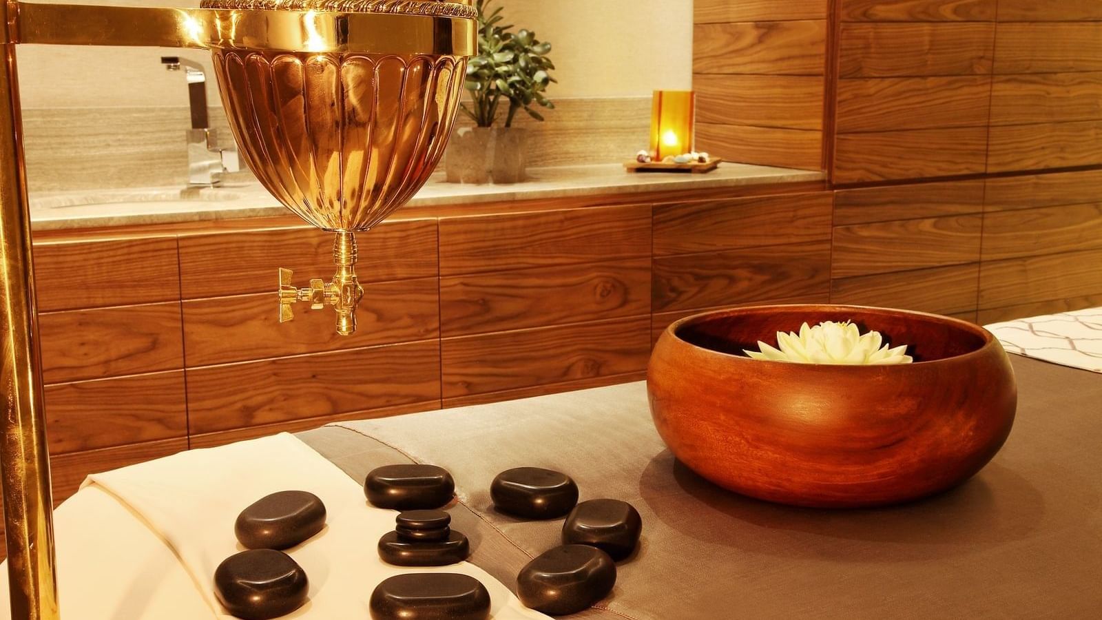 Massage bed with stones & a wooden bowl at Live Aqua Resorts