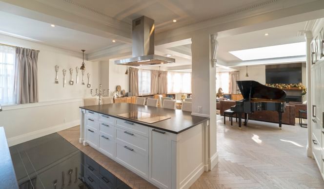 Modern kitchen featuring a piano & a sleek black countertop in Royal Suite at Hotel Port Royal