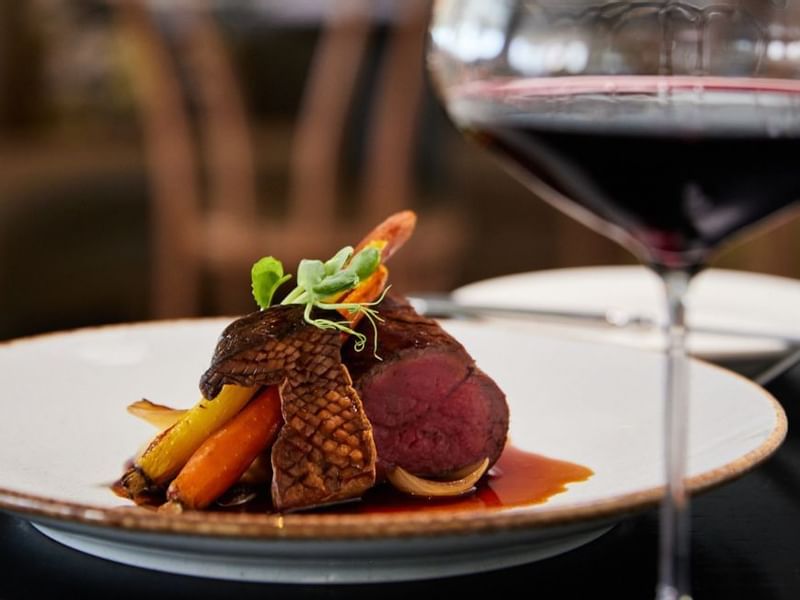 Close-up of a plated dish with wine glass served in Bistro Guillaume at 
Crown Metropol Melbourne