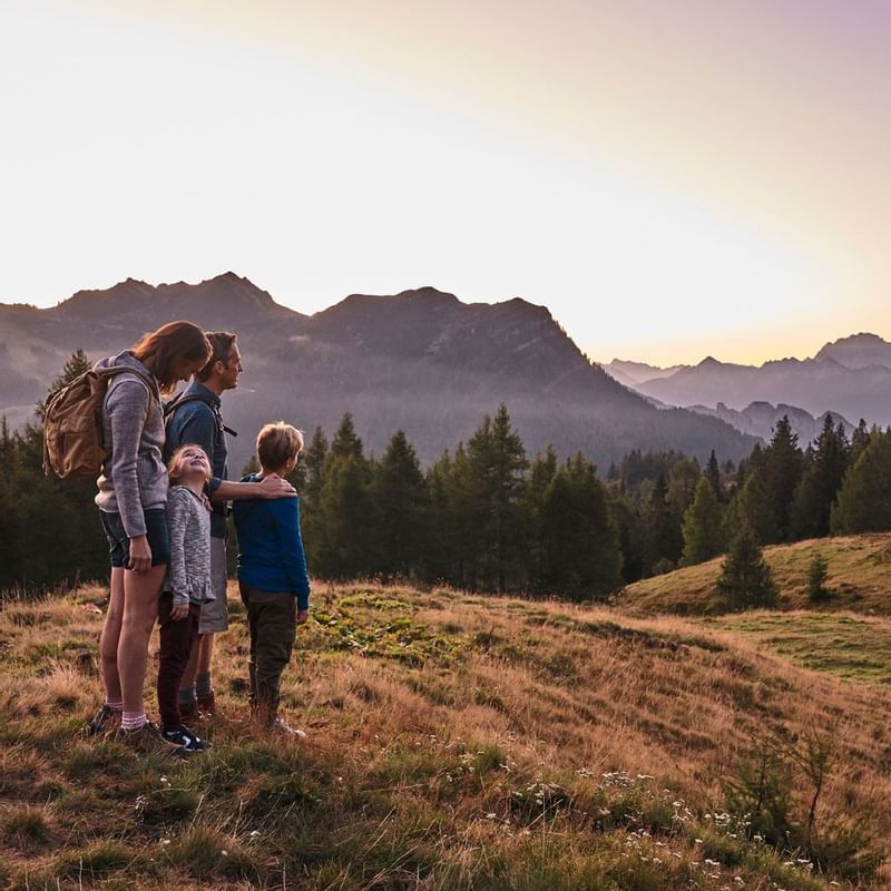 Family on a hike by the mountains near Falkensteiner Hotels