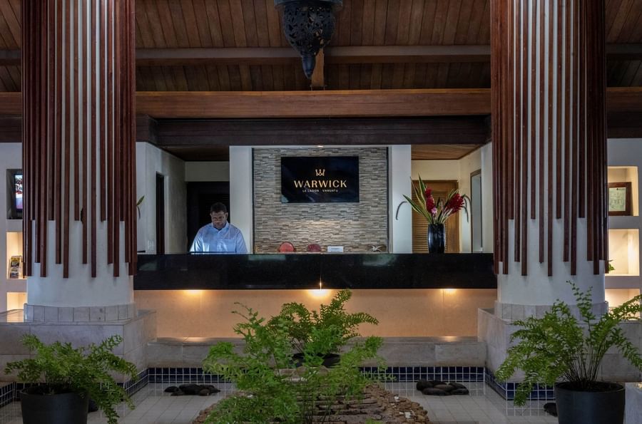 Modern reception desk at Warwick Le Lagon Vanuatu featuring a wooden slat wall design