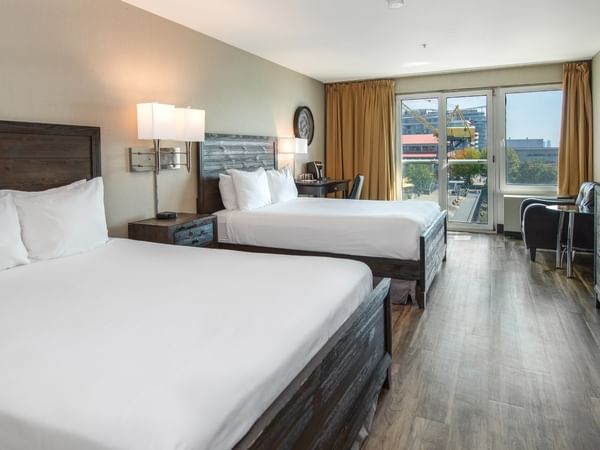 Coast Two Queens with two queen beds, nightstands, dresser, chair, and a TV at Coast Lonsdale Quay Hotel