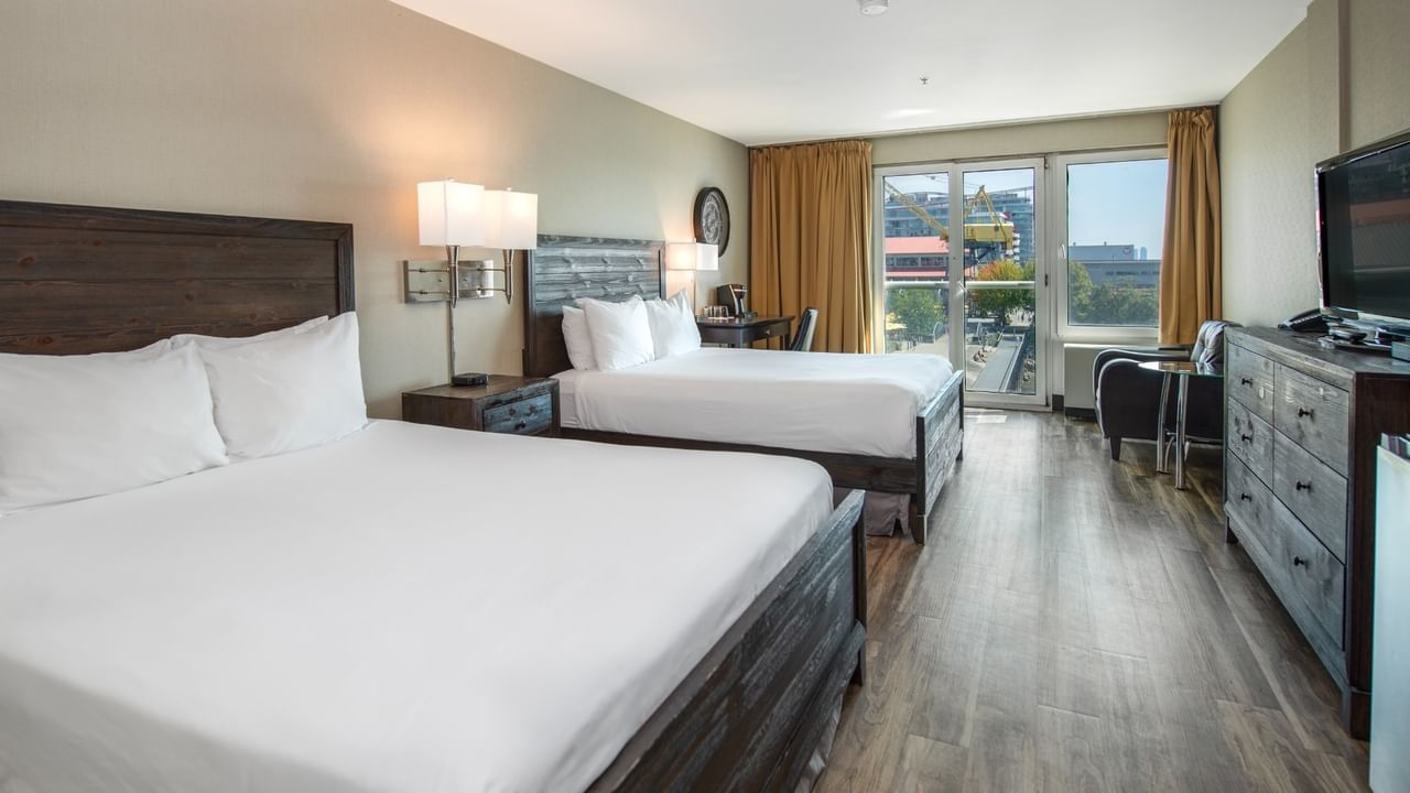 Coast Two Queens with two queen beds, nightstands, dresser, chair, and a TV at Coast Lonsdale Quay Hotel