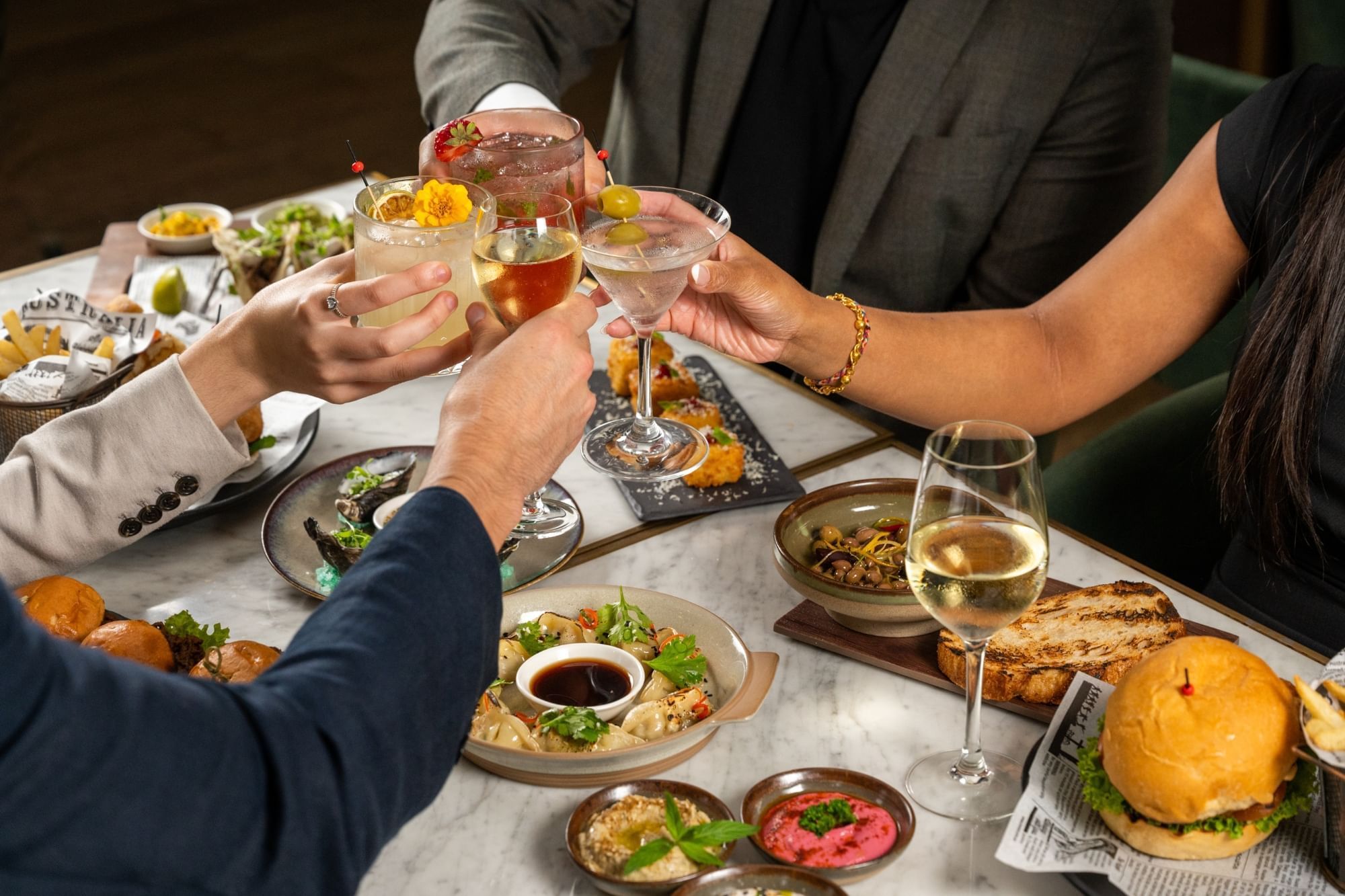 Close-up of a group of people toasting cocktails in BAR THIRTY6 at Pullman Sydney Hyde Park