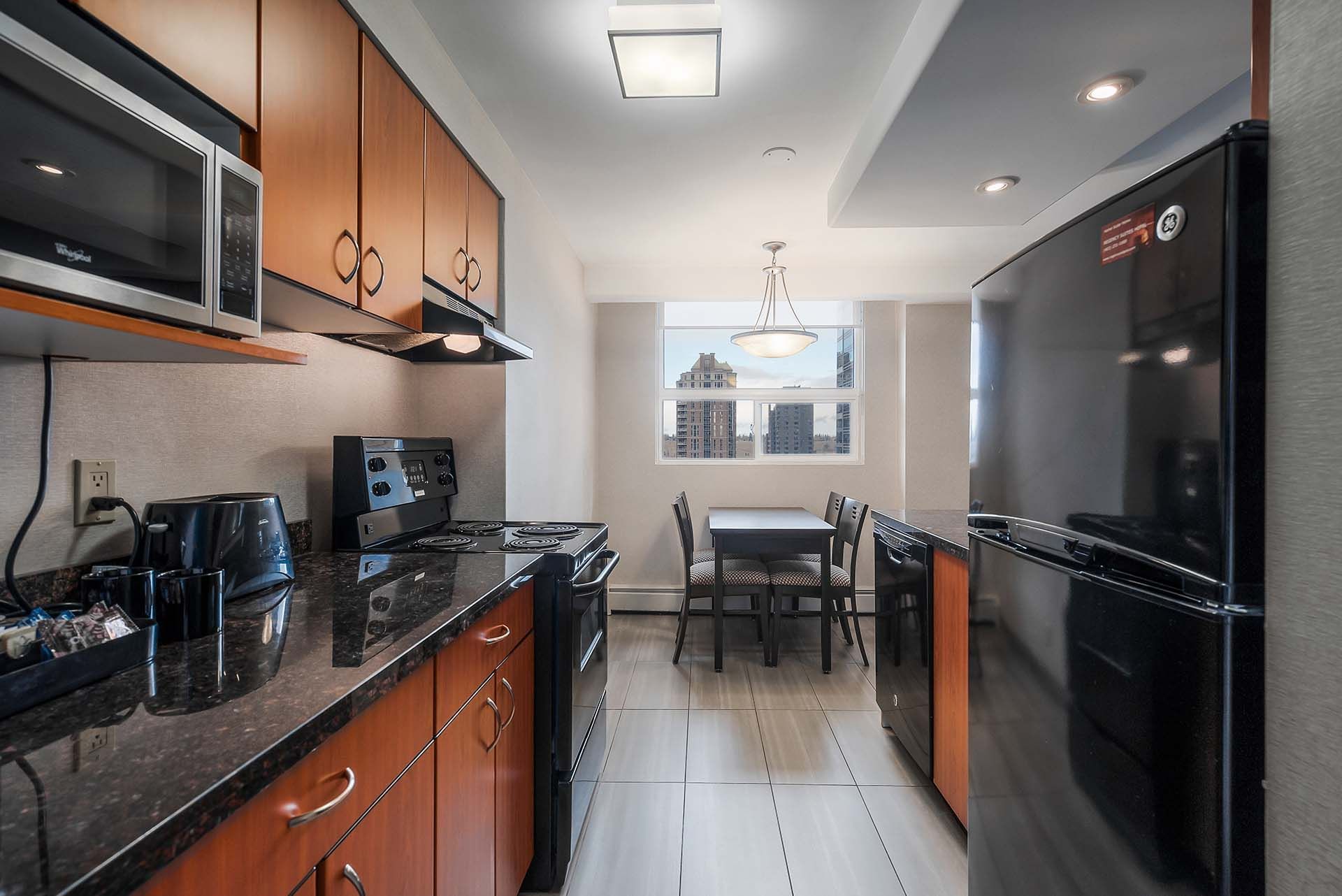 Full kitchen with view of dining area as seen in our one or two bedroom suites