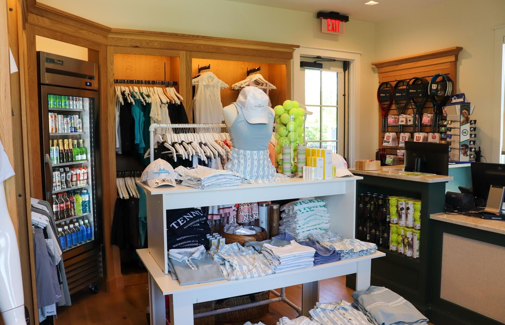 A store with golf apparel, bottles, and tennis rackets at the Camp Creek Tennis and Pickleball Pro Shop.