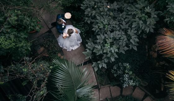 a bride and groom walking on a stone path