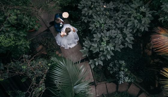 una novia y un novio caminando por un camino de piedra
