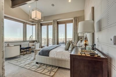 Bedroom with a king bed featuring large windows & interior at Stein Eriksen Residences
