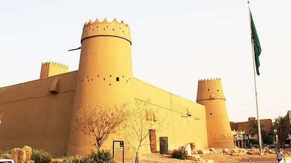 La citadelle de Masmak, avec ses tours circulaires, près d'un drapeau et de plantes du désert, à proximité de l'hôtel Cantonal by Warwick Riyadh