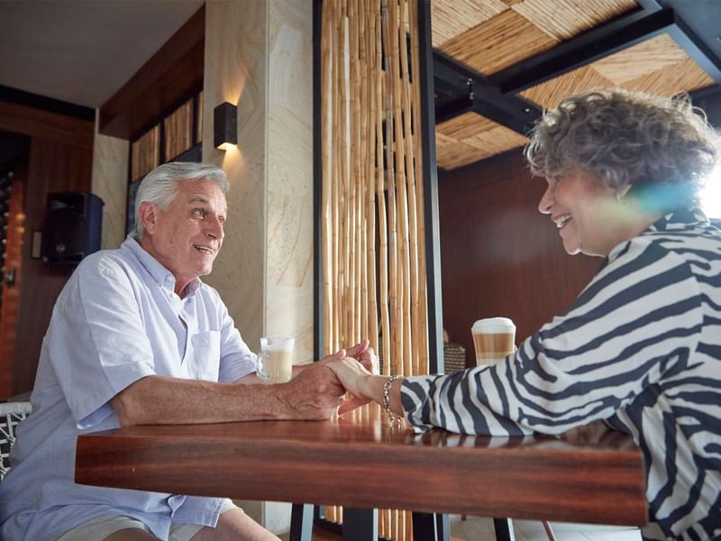 Old couple holding hands while having a coffee at Fiesta Americana