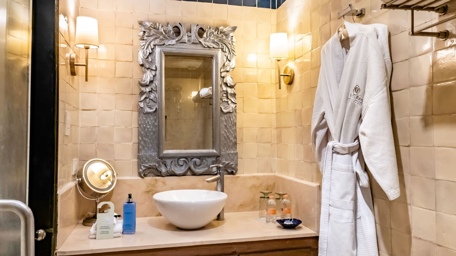 Bathroom of King Novicia room with sink and bathrobe at Quinta Real Puebla in Heroica Puebla de Zaragoza.