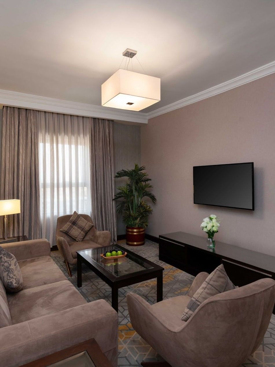 TV lounge area with plush seating and carpeted floors in Executive One-Bedroom Suite at Warwick Hotel Jeddah