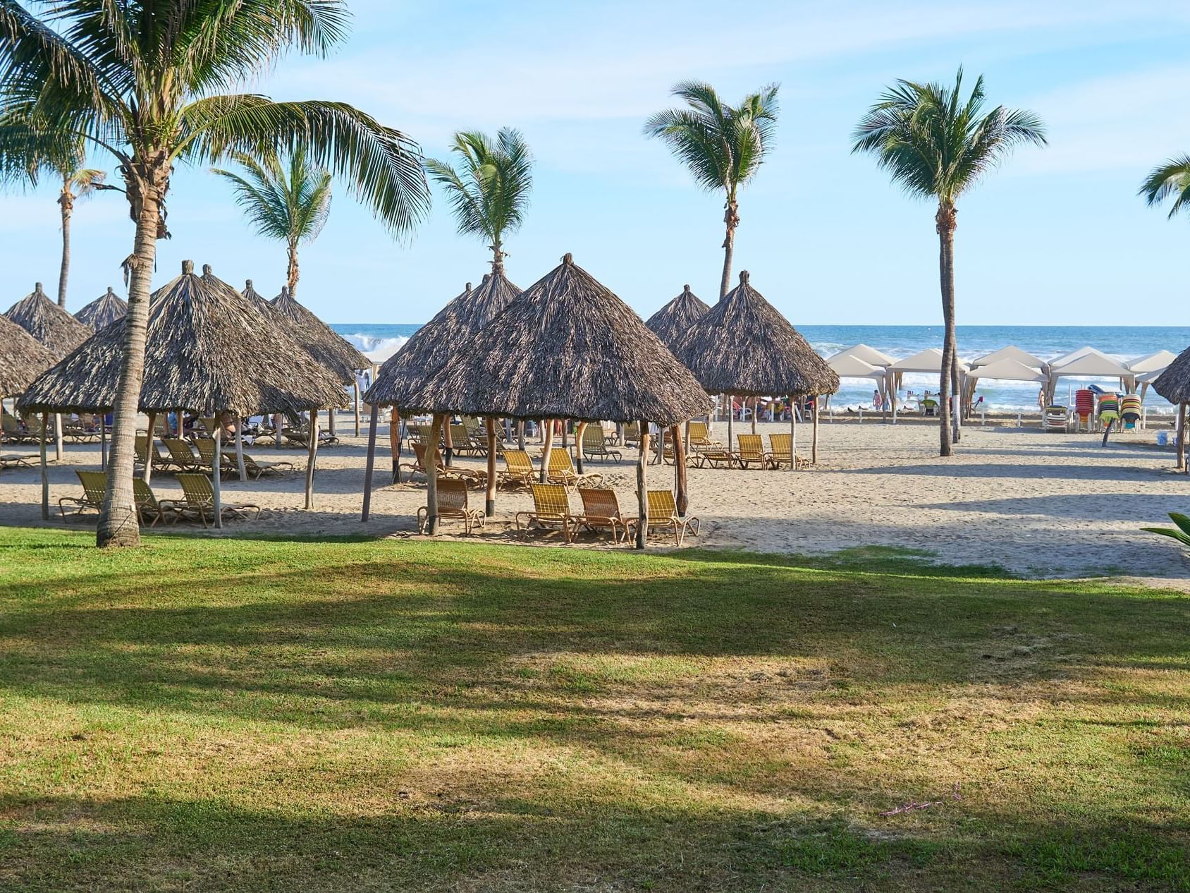 The beach with palm trees & palapas near Mundo Imperial