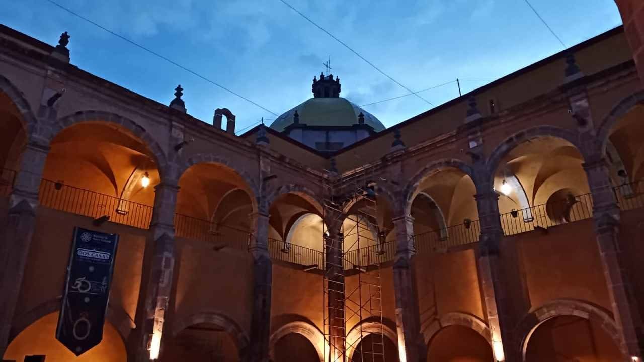 Historic stone courtyard with vaulted arches and a cathedral dome at Camino Real Pedregal Mexico at dusk
