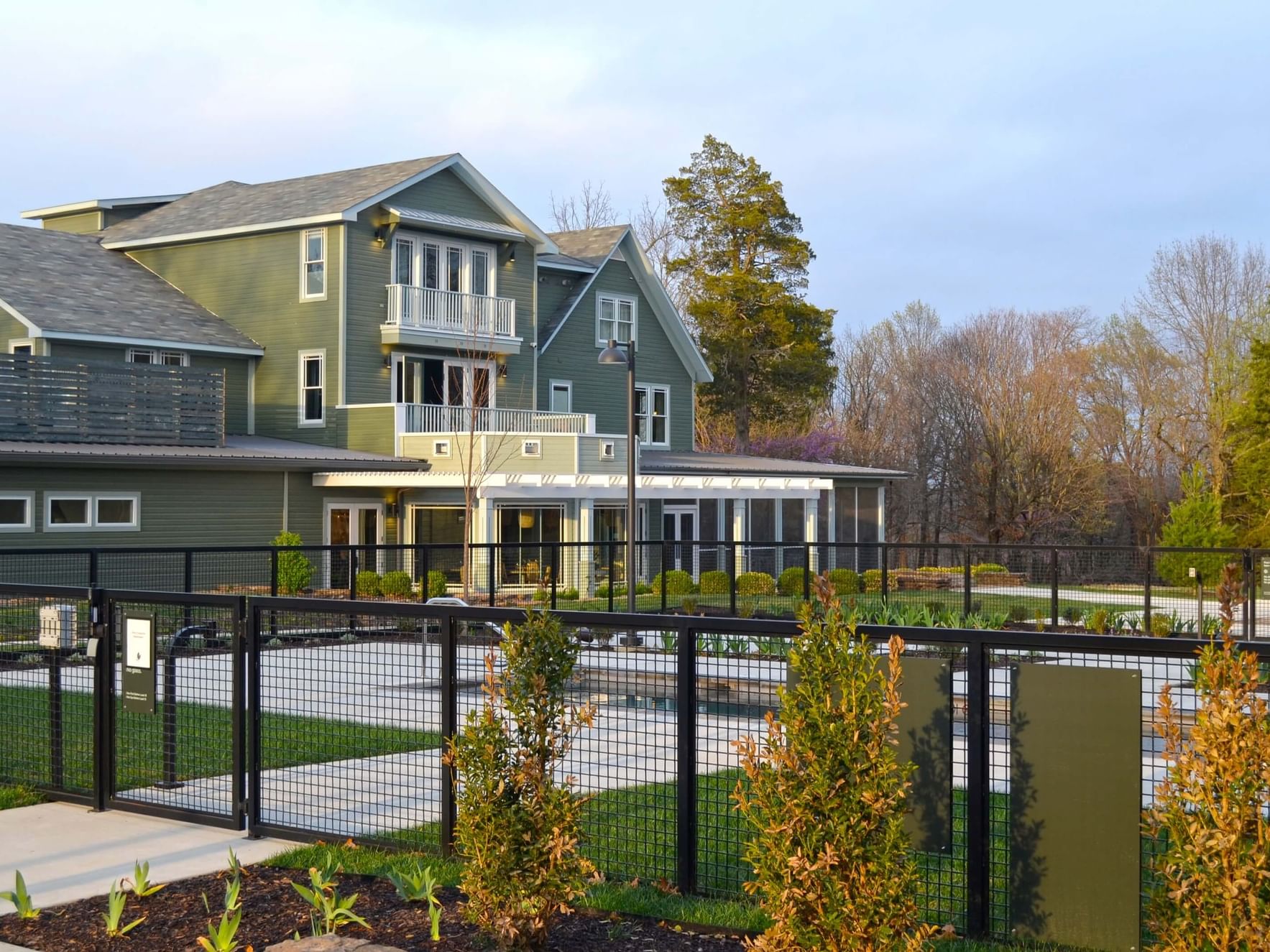 Green building with balconies and fenced garden area Provisions on the Hill.