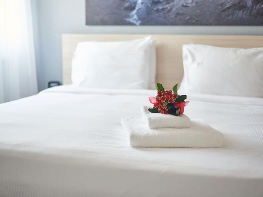 Flowers on a bed with towels at Apart-Hotel Zurich Airport