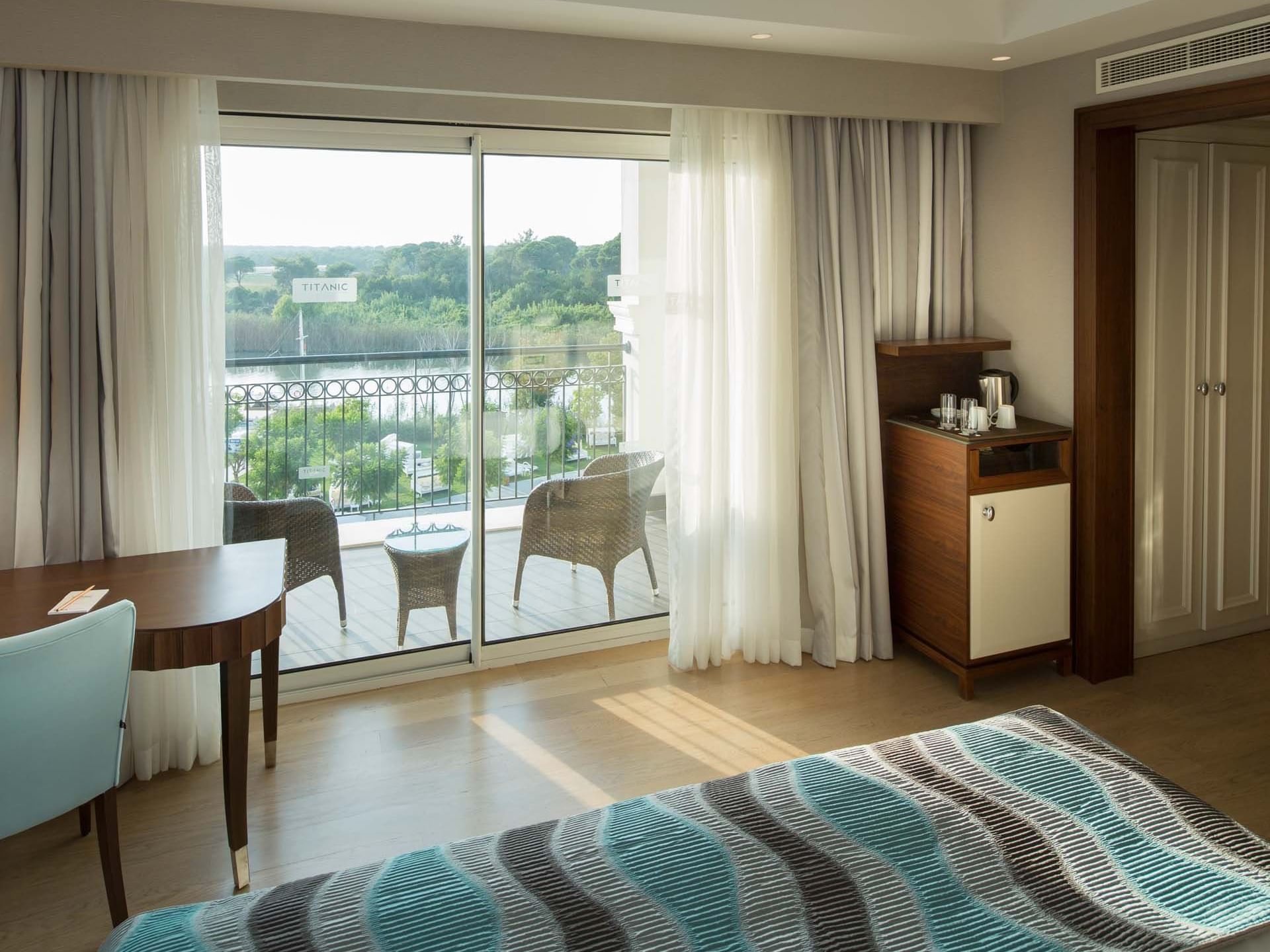 Coffee maker & work desk by the bed in Riverside Room with wooden floors at Titanic Deluxe Golf Belek