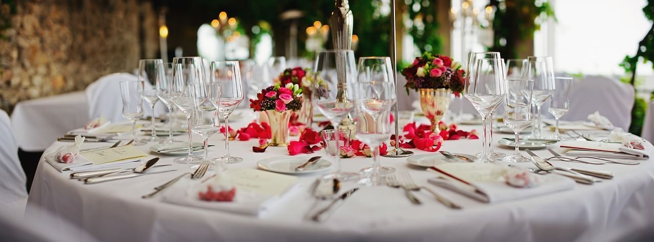 Flowers & glasses arranged in a decorated table for an event at Eastin Residences Vadodara