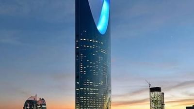 Kingdom Centre tower with a blue lit opening by the city skyline at dusk near Cantonal Hotel by Warwick Riyadh