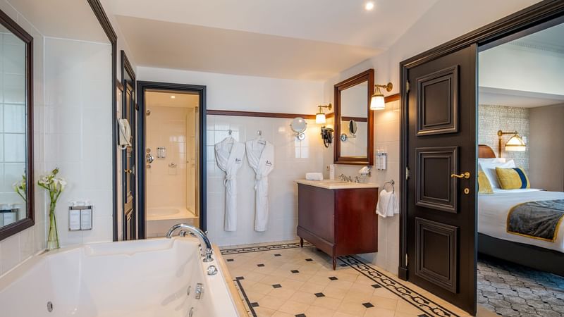 Bathroom with vanity, bathtub & robes in Barsey Suite at Hotel Barsey by Warwick - Brussels