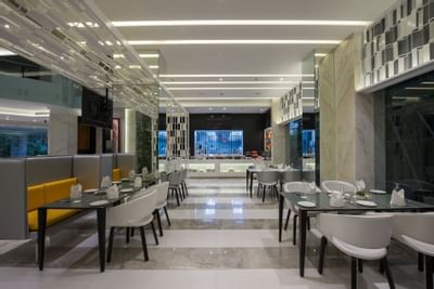Arranged dining area by the reception in The Glass House at Eastin Residences Vadodara