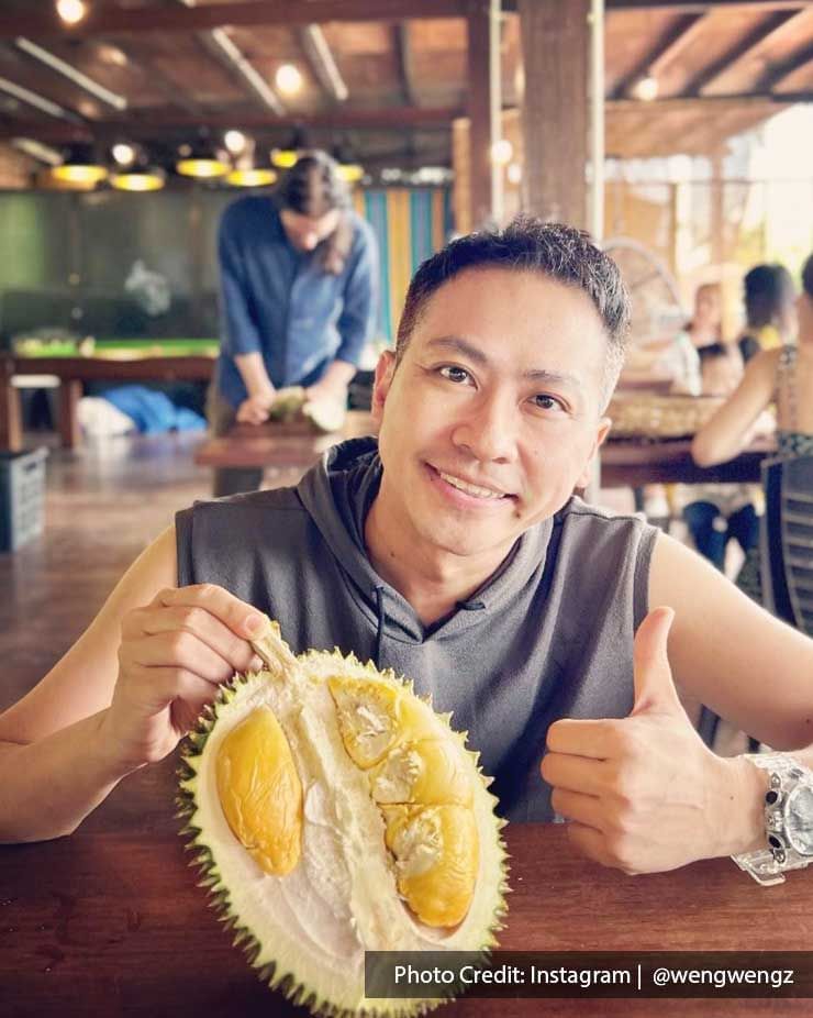 A man was taking a picture with a durian at Bao Sheng Durian Farm - Lexis Suites Penang