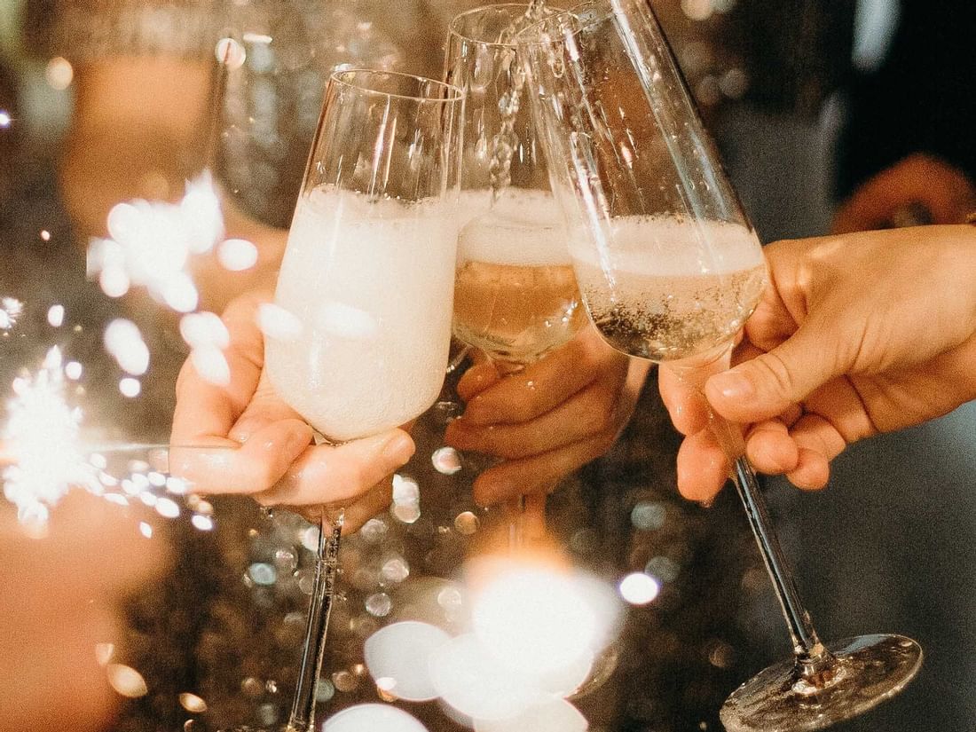 Guests toast with sparkling wine at a lively celebration near The Sebel Mandurah, holding festive sparklers