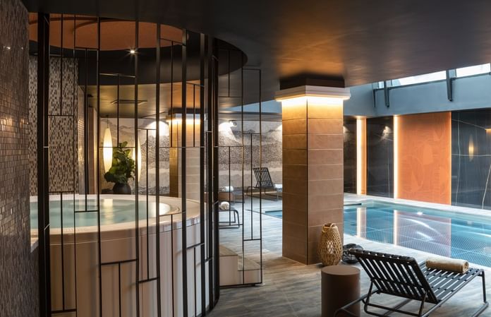 Interior of Indoor pool area with lounge chairs at Oceania Hotels