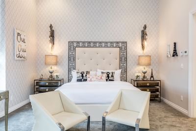 Bedroom of King Premiere Paris with comfy chairs, lamps & large bed at Retro Suites Hotel