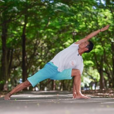 A man doing yoga poses outdoors at Maitria Hotel Sukhumvit 18