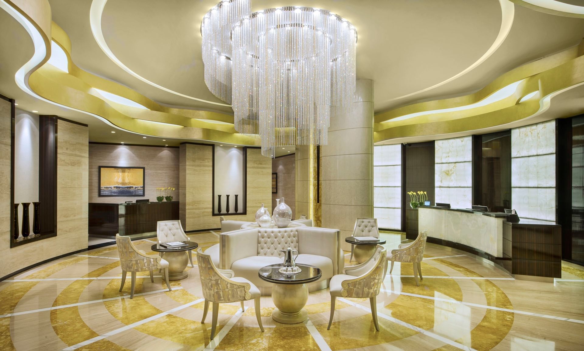 Luxurious lobby with elegant chairs, a grand chandelier, and modern decor at DAMAC Maison Cour Jardin