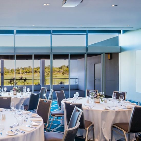 formal set up in conference room with round tables overlooking golf course on the central coast