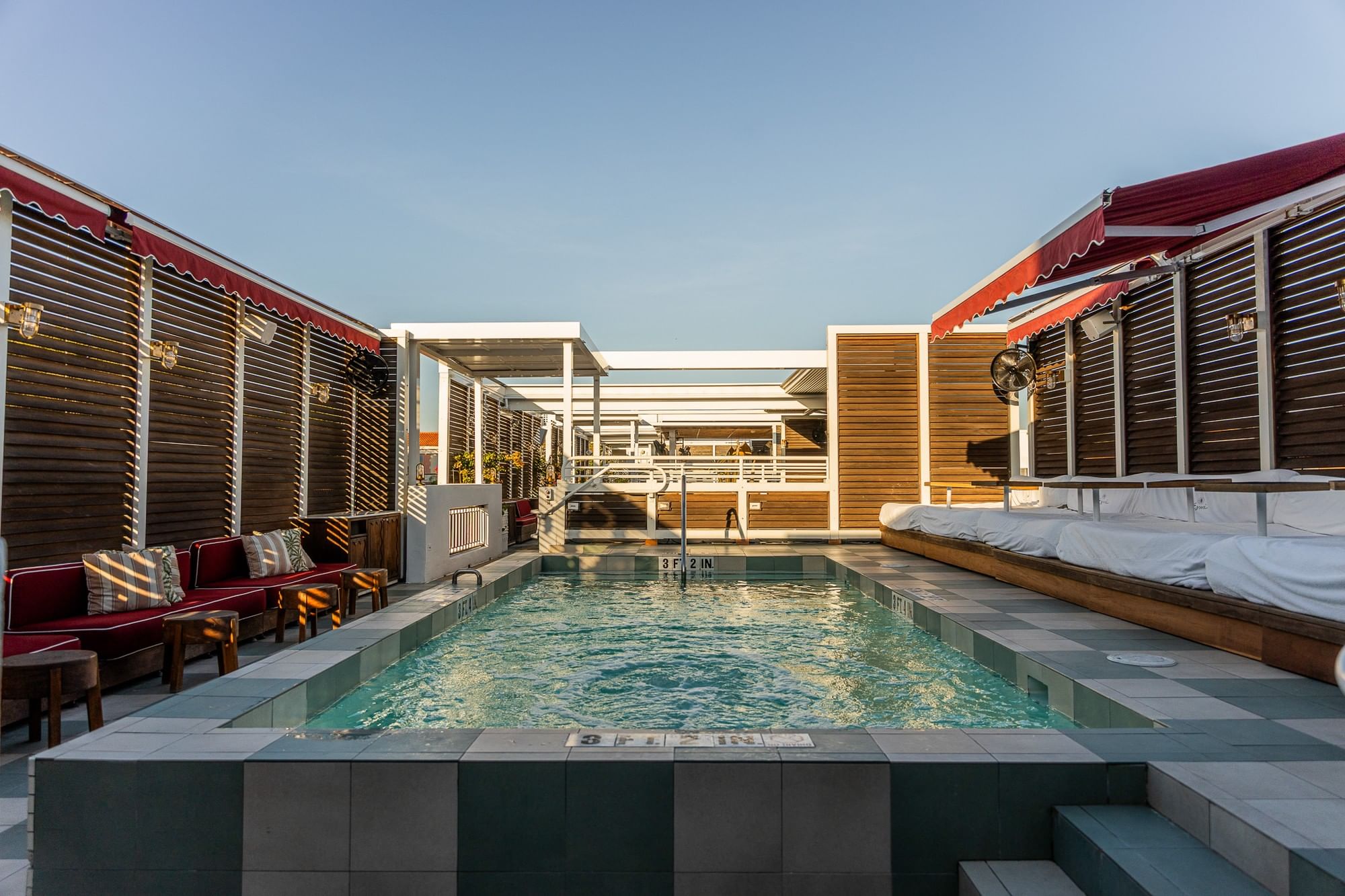 A swimming pool with lounge seating and cabanas