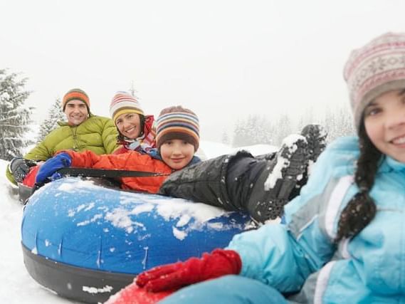 Family enjoying winter fun on snow tube near Stein Eriksen Lodge